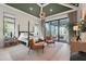 A luxurious main bedroom with a decorative ceiling and a view of the covered outdoor living space and lake at 1182 Blue Shell Loop, Sarasota, FL 34240