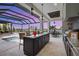 Outdoor kitchen with island bar, granite counters, stainless grill, and stunning views of pool and waterfront at 1182 Blue Shell Loop, Sarasota, FL 34240