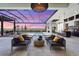 Elegant outdoor living area with comfortable seating, summer kitchen, and a stunning view of the water and pool at 1182 Blue Shell Loop, Sarasota, FL 34240