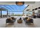Lavish outdoor living space with pool, covered seating area, complete with outdoor kitchen overlooking the lake at 1182 Blue Shell Loop, Sarasota, FL 34240