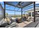 Covered outdoor area featuring a built-in fire pit, lounge area, and views of the pool and waterway at 1182 Blue Shell Loop, Sarasota, FL 34240
