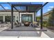 Covered outdoor space with built-in fire pit, ceiling fan, and comfortable seating with view of lawn and lake at 1182 Blue Shell Loop, Sarasota, FL 34240