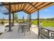 A covered pavilion with metal and wood beams offers a shaded seating area with tables and chairs for relaxing outside at 1182 Blue Shell Loop, Sarasota, FL 34240