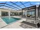 The covered pool area has a water view, fire pit, lounge seating and an outdoor kitchen at 1182 Blue Shell Loop, Sarasota, FL 34240