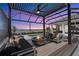Relaxing backyard featuring a covered patio with a fire pit, a pool and peaceful lake views at 1182 Blue Shell Loop, Sarasota, FL 34240
