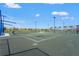 Outdoor tennis court with pristine green surface, surrounded by fencing and landscaping at 1182 Blue Shell Loop, Sarasota, FL 34240