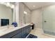 Modern bathroom featuring double sinks, a glass-enclosed shower, and elegant blue cabinetry at 12175 Maple Ridge Dr, Parrish, FL 34219