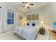 Cozy bedroom featuring a queen-sized bed with striped bedding, ceiling fan, and decorative wall art at 12175 Maple Ridge Dr, Parrish, FL 34219