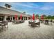 Outdoor patio area with tables, chairs, and red umbrellas, perfect for dining and relaxation at 12175 Maple Ridge Dr, Parrish, FL 34219