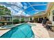 Sparkling pool and spa with screened enclosure, complemented by ample patio space and lush landscaping for outdoor enjoyment at 12175 Maple Ridge Dr, Parrish, FL 34219
