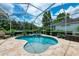 Beautiful screened-in pool and spa with travertine deck and lush landscaping for backyard bliss at 12175 Maple Ridge Dr, Parrish, FL 34219
