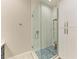 Modern shower features a frameless glass door and blue tiled floor with a built-in bench and storage at 12175 Maple Ridge Dr, Parrish, FL 34219