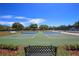 Well-maintained community tennis courts with a seating area and manicured landscaping at 12175 Maple Ridge Dr, Parrish, FL 34219