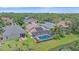 Aerial view of property featuring an in-ground pool, solar panels, lush landscaping, and neighborhood views at 12322 Tall Pines Way, Lakewood Ranch, FL 34202