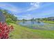 Lush backyard view with a serene lake, vibrant foliage, and several homes dotting the shore at 12322 Tall Pines Way, Lakewood Ranch, FL 34202