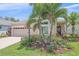 Charming single-story home with a well-manicured lawn and lush tropical landscaping at 12322 Tall Pines Way, Lakewood Ranch, FL 34202