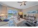 Elegant living room with plush seating, view of pool, and a ceiling fan at 12322 Tall Pines Way, Lakewood Ranch, FL 34202