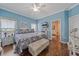 Comfortable main bedroom with a plush bed, stylish bench, and blue accent wall at 12322 Tall Pines Way, Lakewood Ranch, FL 34202