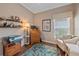 Home office with desk, printer, chair, hardwood floor, and decorations on display shelves at 12322 Tall Pines Way, Lakewood Ranch, FL 34202