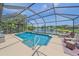Screened-in pool with clear blue water, poolside seating, and a scenic lake view at 12322 Tall Pines Way, Lakewood Ranch, FL 34202