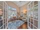 Bright sitting room with cozy chairs, a large window, and French doors at 12322 Tall Pines Way, Lakewood Ranch, FL 34202