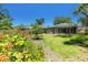 Picturesque backyard showcasing lush landscaping, grassy lawn, and a screened-in lanai at 135 Tall Trees Ct, Sarasota, FL 34232