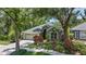 Charming one-story home with lush landscaping, green exterior, and a two-car garage at 135 Tall Trees Ct, Sarasota, FL 34232
