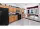 Functional kitchen featuring wood cabinets, black appliances, and granite countertops at 135 Tall Trees Ct, Sarasota, FL 34232