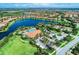 An aerial view of a Primary-planned community showcasing a lake, community center, and tennis courts at 13710 Messina Loop # 201, Bradenton, FL 34211