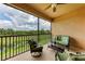 Relaxing screened balcony with comfortable seating and views of a pond and lush landscape at 13710 Messina Loop # 201, Bradenton, FL 34211