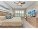 Comfortable bedroom featuring a large bed, dresser with a TV, and natural light from shuttered windows at 13710 Messina Loop # 201, Bradenton, FL 34211