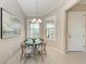 Cozy dining area features a round table, chandelier, and natural light from two windows with shutter blinds at 13710 Messina Loop # 201, Bradenton, FL 34211