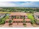 Beautiful building with terracotta tile roof, garages, lush landscaping, and lake view in the background at 13710 Messina Loop # 201, Bradenton, FL 34211