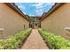 View of exterior walkway with lush landscaping leading to building at 13710 Messina Loop # 201, Bradenton, FL 34211