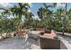 Cozy outdoor seating area with a modern fire pit surrounded by lush greenery and palm trees at 13710 Messina Loop # 201, Bradenton, FL 34211