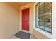 View of a red front door with sidelight window and welcome mat at 13710 Messina Loop # 201, Bradenton, FL 34211