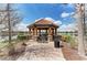 Community gazebo, set by the water, features a terracotta tile roof and stone accents for outdoor relaxation at 13710 Messina Loop # 201, Bradenton, FL 34211