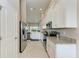 Modern kitchen featuring stainless steel appliances, white cabinetry, granite counters, and tile flooring at 13710 Messina Loop # 201, Bradenton, FL 34211