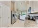 Spacious kitchen boasting stainless steel appliances, a breakfast bar, white cabinets and a view into the living area at 13710 Messina Loop # 201, Bradenton, FL 34211