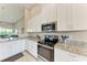 Well-lit kitchen features stainless steel appliances, stylish cabinetry, granite countertops, and sleek design at 13710 Messina Loop # 201, Bradenton, FL 34211