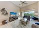 Cozy living room with comfortable seating, a ceiling fan, and a sliding glass door with a view to the outdoor at 13710 Messina Loop # 201, Bradenton, FL 34211