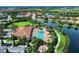 Aerial view featuring the community pool, clubhouse, and landscaped walking path near the lake at 13710 Messina Loop # 201, Bradenton, FL 34211