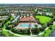 Aerial view of a community pool and clubhouse surrounded by lush landscaping and a lake at 13710 Messina Loop # 201, Bradenton, FL 34211