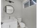 This bathroom features a modern round mirror, granite vanity with white cabinets, and a low-flow toilet at 14065 Paris Ln, Port Charlotte, FL 33981