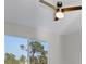 Bedroom showcasing a modern ceiling fan and a large window with a view of surrounding trees at 14065 Paris Ln, Port Charlotte, FL 33981