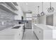 Bright, modern kitchen featuring sleek white cabinets, stainless steel appliances, and a large island with quartz countertops at 14065 Paris Ln, Port Charlotte, FL 33981