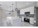 Modern kitchen with stainless steel appliances, mosaic backsplash, and island with pendant lighting at 14065 Paris Ln, Port Charlotte, FL 33981