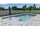 This home features a beautiful private pool with stone steps, surrounded by brick pavers and a manicured lawn at 14065 Paris Ln, Port Charlotte, FL 33981