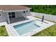 This aerial view shows a beautiful private pool, surrounded by brick pavers and a white privacy fence at 14065 Paris Ln, Port Charlotte, FL 33981
