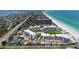 Aerial view of beachfront condos with beautiful beaches, lush landscaping, tennis courts, and a pool at 1465 Gulf Of Mexico Dr # 502, Longboat Key, FL 34228